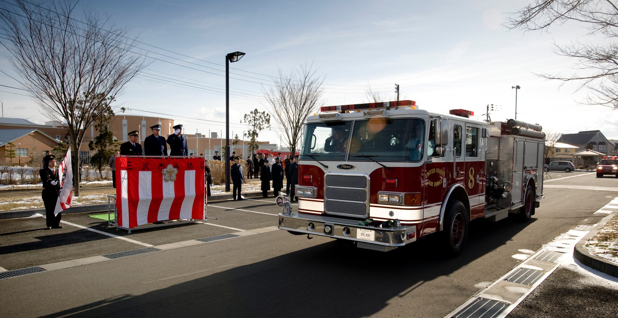 MISAWA CITY, Japan -- Col. David Stilwell, 35th Fighter Wing commander, salutes a 35th Civil Engineer Squadron fire truck as it drives by during a pass and review outside the Misawa Ice Arena Jan. 11. Approximately 300 participants attended the event. (U.S. Air Force photo/Staff Sgt. Samuel Morse)