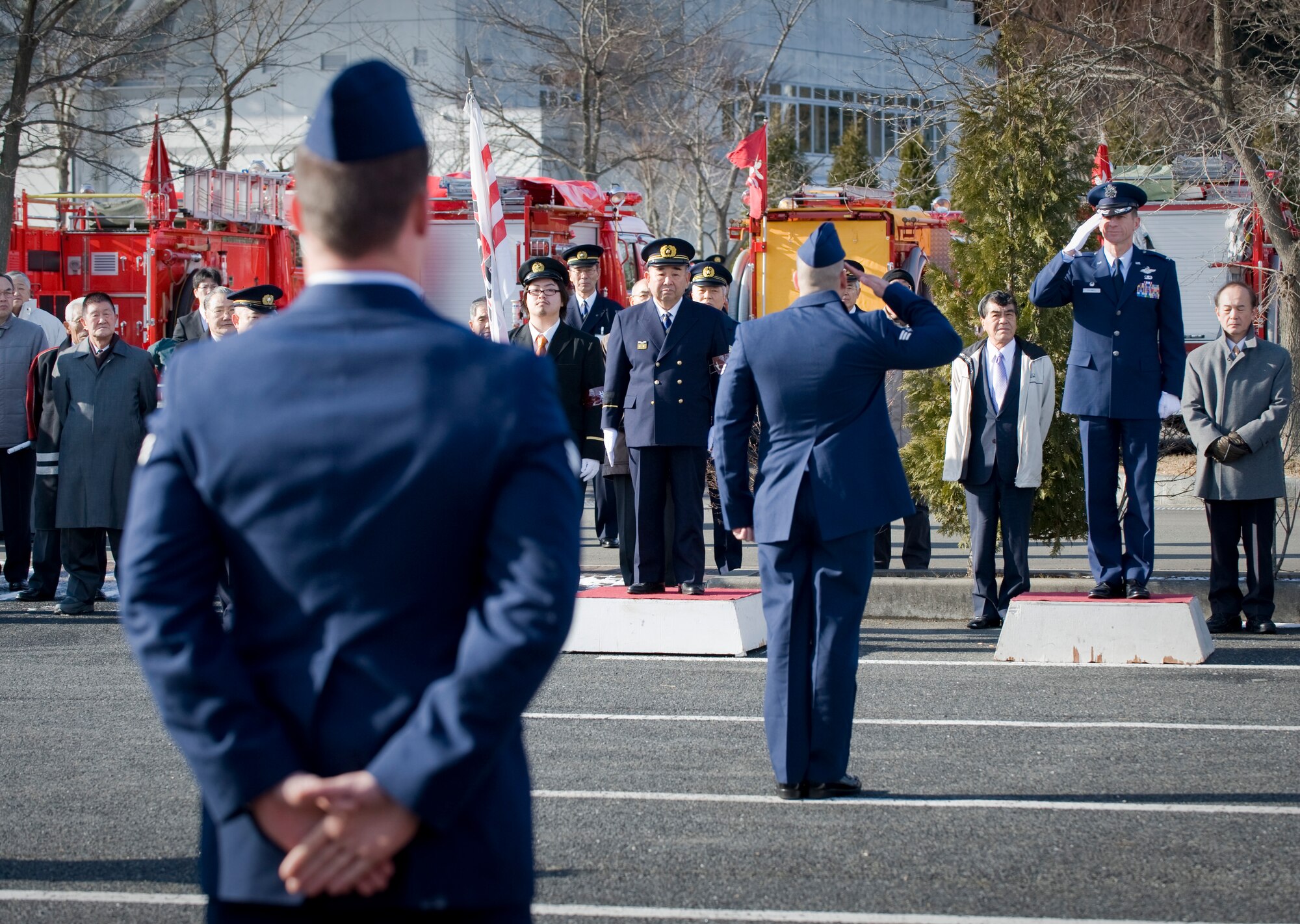 MISAWA CITY, Japan -- Senior Airman Christopher Carey, 35th Civil Engineer Squadron firefighter, salutes Col. David Stilwell, 35th Fighter Wing commander, at the conclusion of their fire truck demonstration at the Misawa Ice Arena Jan. 11. Airman Carey and his team demonstrated the capabilities of their fire truck for Misawa City officials. (U.S. Air Force photo/Staff Sgt. Samuel Morse)