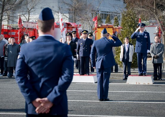 MISAWA CITY, Japan -- Senior Airman Christopher Carey, 35th Civil Engineer Squadron firefighter, salutes Col. David Stilwell, 35th Fighter Wing commander, at the conclusion of their fire truck demonstration at the Misawa Ice Arena Jan. 11. Airman Carey and his team demonstrated the capabilities of their fire truck for Misawa City officials. (U.S. Air Force photo/Staff Sgt. Samuel Morse)
