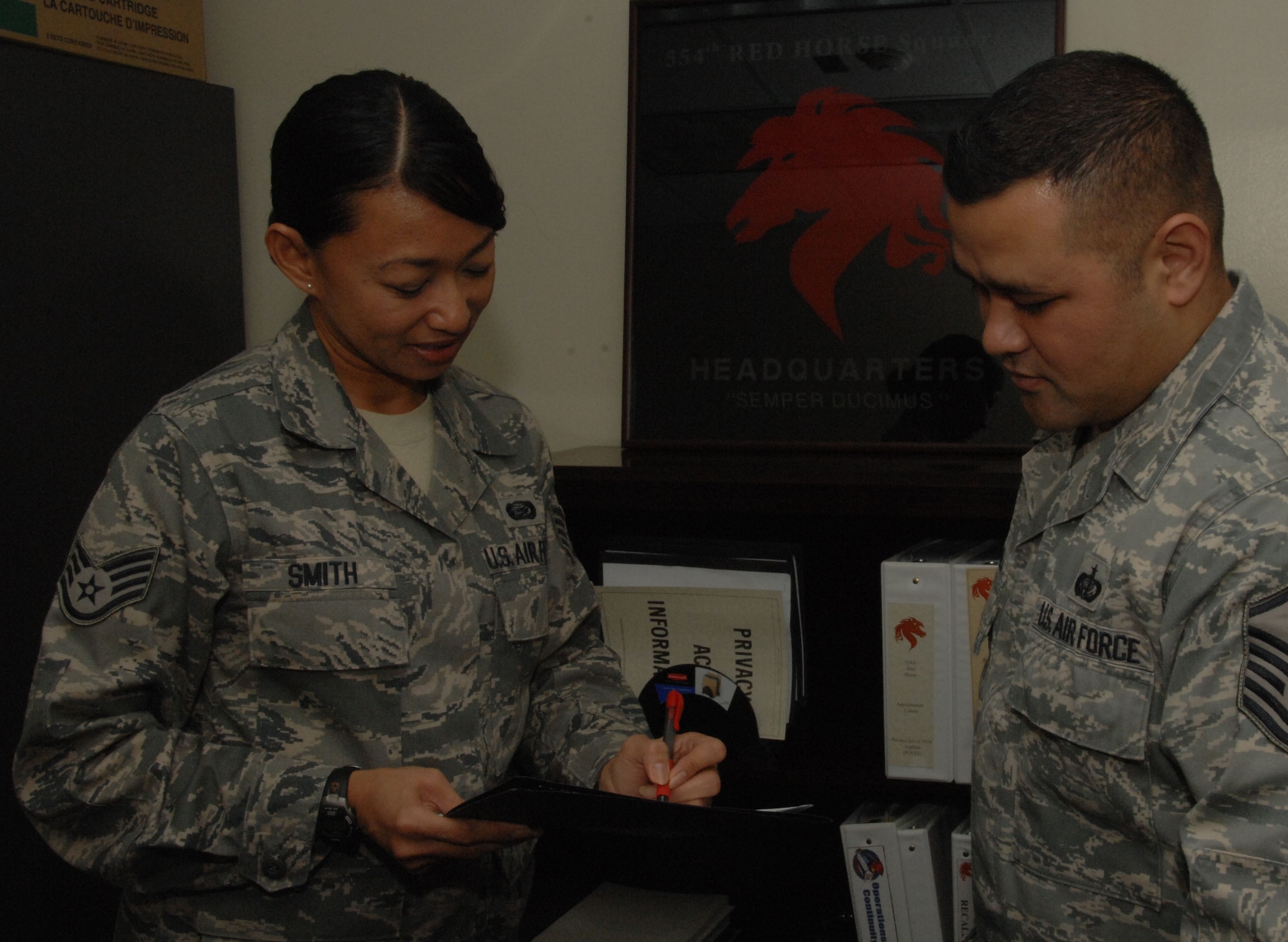 ANDERSEN AIR FORCE BASE, Guam - Staff Sgt. Elsie Smith, 554th RED HORSE Squadron, reviews documents with Master Sgt. Norbert Mendiola, 554th RED HORSE guard liaison here Jan. 15. Sergeant Smith, originally from the 254th Air Base Group here, was named 'Top Performer' for the 554th RHS by Master Sgt. Wesley Willand, 544th RHS first sergeant. (U.S. Air Force photo by Senior Airman Shane Dunaway)