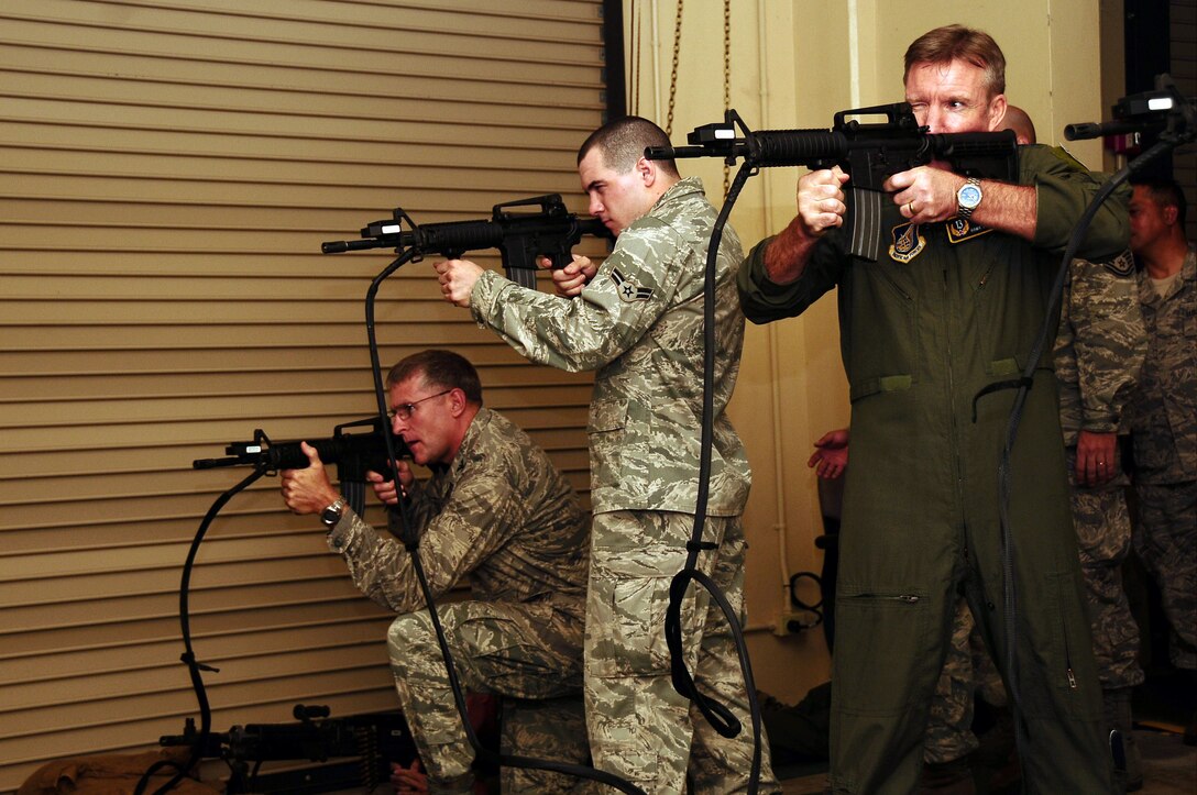 ANDERSEN AIR FORCE BASE, Guam -- (right) Lt. Gen. Hawk Carlisle, commander of 13th Air Force, and members of the 36th Wing fire replica M-4 Carbine automatic rifles at simulated targets at the Warrior Skills Trainer here  Jan. 14. This is the general's first visit to Andersen since assuming command of 13th Air Force. (U.S.Air Force photo by Airman 1st Class Jeffrey Schultze)