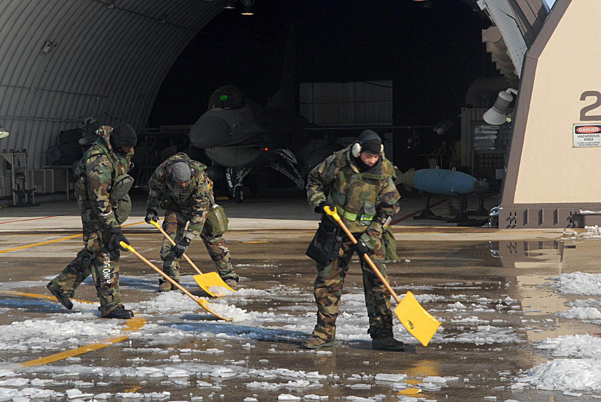 KUNSAN AIR BASE, Republic of Korea -- Staff Sgt. Frantavious Dooley, Staff Sgt. Trebor Lindstamer, and Senior Airman Kenneth Moore, all weapons load crew members assigned to the 8th Maintenance Squadron, remove snow from the runway during the Peninsula-wide Operational Readiness Exercise here, Jan. 14. Kunsan received more than 16 inches of snow, and Airmen cleared it from the flightline, taxiways and hardened shelters within 10 hours to get aircraft in the air to fly missions. (U.S. photo/Senior Airman Roy Lynch)