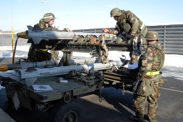 KUNSAN AIR BASE, Republic of Korea -- Staff Sgt. Albert Golder and Airman 1st Class Alpha Barry inspect the Captive Air Training Missile while Senior Airman Duane Asbell reads the technical orders for the post-use of the CATM during a Peninsula-wide Operational Readiness Exercise here, Jan. 14. Sergeant Golder and Airmen Asbell and Barry are precision-guided munitions crew chiefs assigned to the 8th Maintenance Squadron. PENOREs like this one ensure that all Wolf Pack members are capable of performing their duties in wartime conditions; that they are ready to defend the base, accept follow on forces and take the fight north. (U.S. photo/Staff Sgt. Darnell T. Cannady)