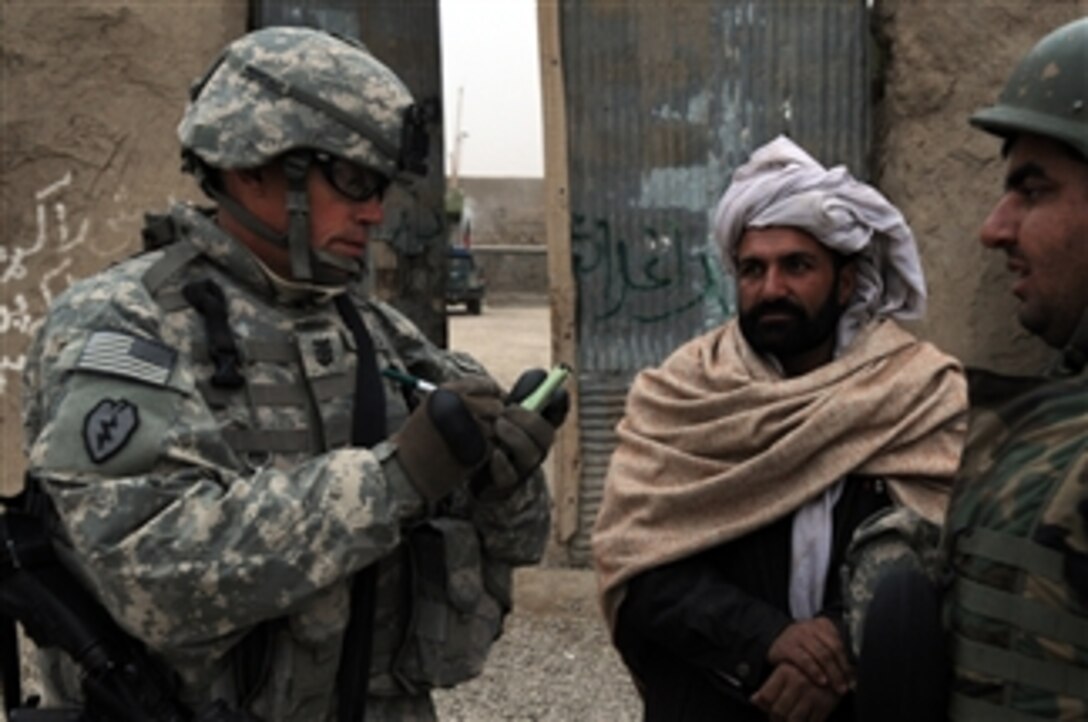 U.S. Navy Master Chief Petty Officer Glenn Niemitalo, an engineer with the Paktika Provincial Reconstruction Team, talks to a village elder with the assistance of an interpreter about upcoming development projects in Jani Khel, Afghanistan, on Jan. 9, 2010.  