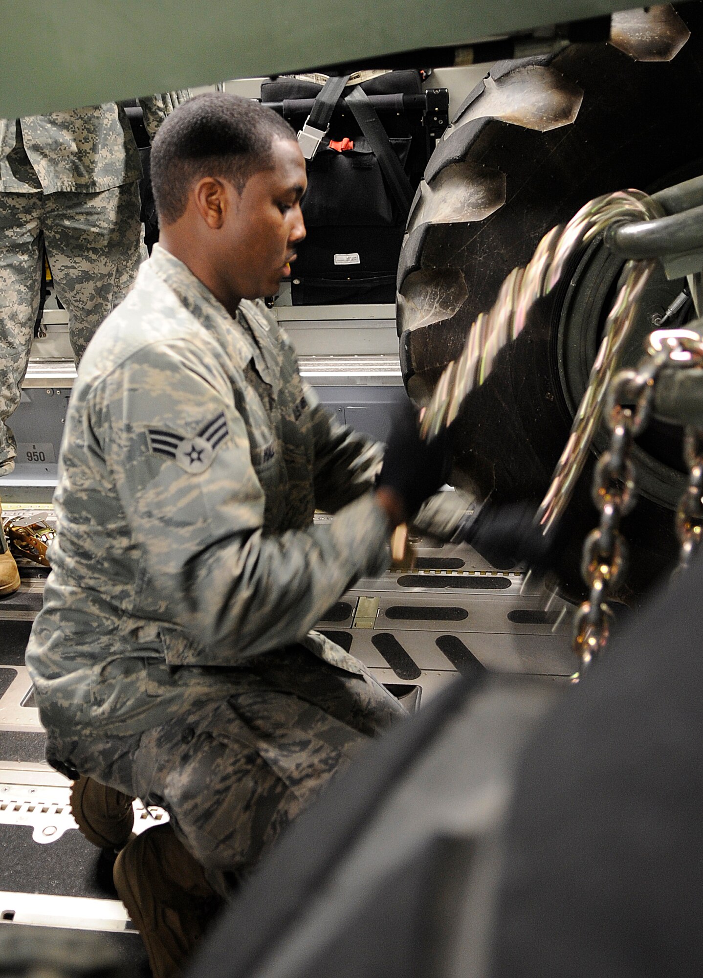 LANGLEY AIR FORCE BASE, Va. – Senior Airman Timothy Hall, 633d Logistic Readiness Squadron Air Transportation journeyman, secures a forklift to the bed of a C-17 Globemaster III cargo aircraft Jan. 16. Air Force and Army personnel from Langley and Fort Eustis, Va., loaded equipment and supplies onto the aircraft to support relief efforts, save lives and alleviate human suffering following the devastating earthquake that struck Haiti on Jan. 12. (U.S. Air Force photo/ Senior Airman Dana Hill)