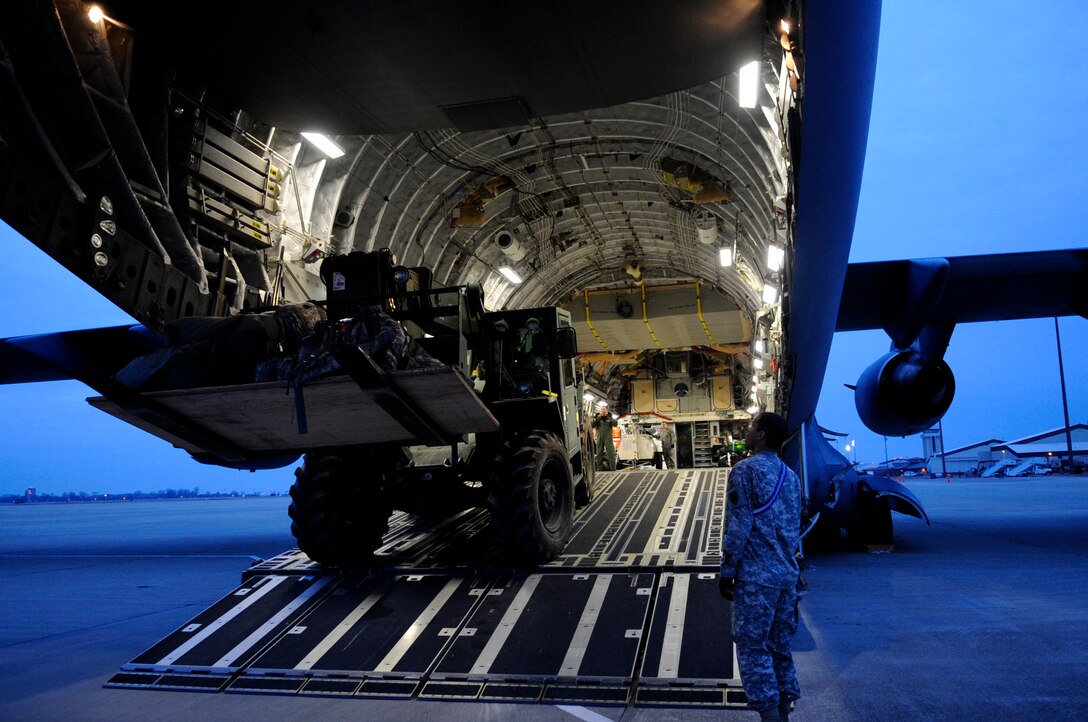 LANGLEY AIR FORCE BASE, Va. – United Sates Army Sgt. Nickolas Lewis, 164th Terminal Supervisor Team, 7th Special Troops Battalion, observes equipment being loaded onto the back of a C-17 Globemaster III cargo aircraft Jan. 16. Air Force and Army personnel from Langley and Fort Eustis, Va., loaded equipment and supplies onto the aircraft to support relief efforts, save lives and alleviate human suffering following the devastating earthquake that struck Haiti on Jan. 12. (U.S. Air Force photo/ Senior Airman Dana Hill)