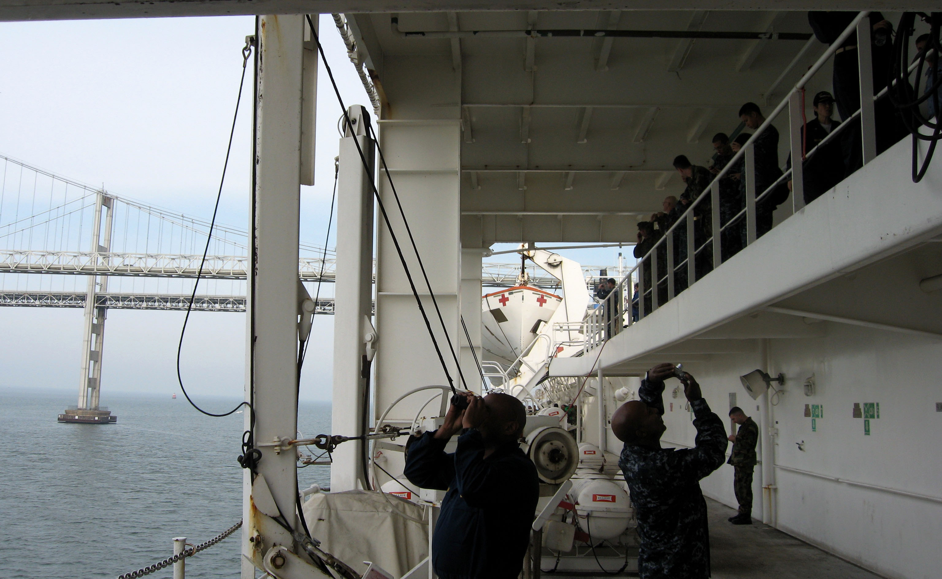 Passengers aboard the USNS Comfort take photos as the hospital ...