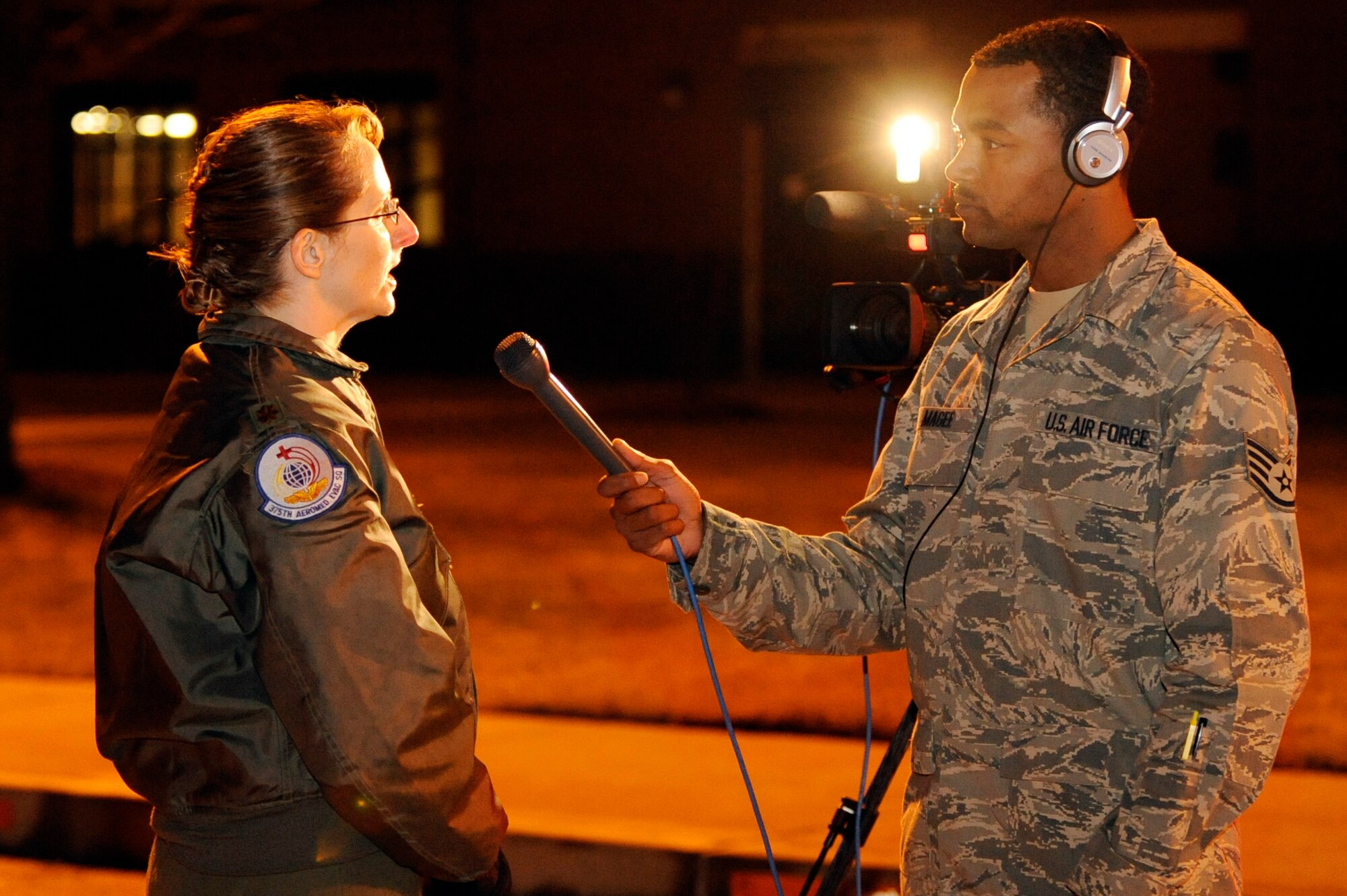 Staff Sgt. Bryan Magee, 375th Air Mobility Wing Public Affairs Broadcaster, interviews Maj. Melissa Steckler, 375th Aeromedical Evacuation Squadron flight nurse, on the Scott AFB, Ill., runway about the missions she and her AES team will work as they are staged out of MacDill Air Force Base, Fla. The AE team will be placed on alert there to transport wounded and ill people back to the United States from Haiti for medical care. The aircraft will continue on to Haiti with medical relief supplies and an AE team from U.S. Transportation Command.  (U.S. Air Force photo/ Senior Airman Wesley Farnsworth)
