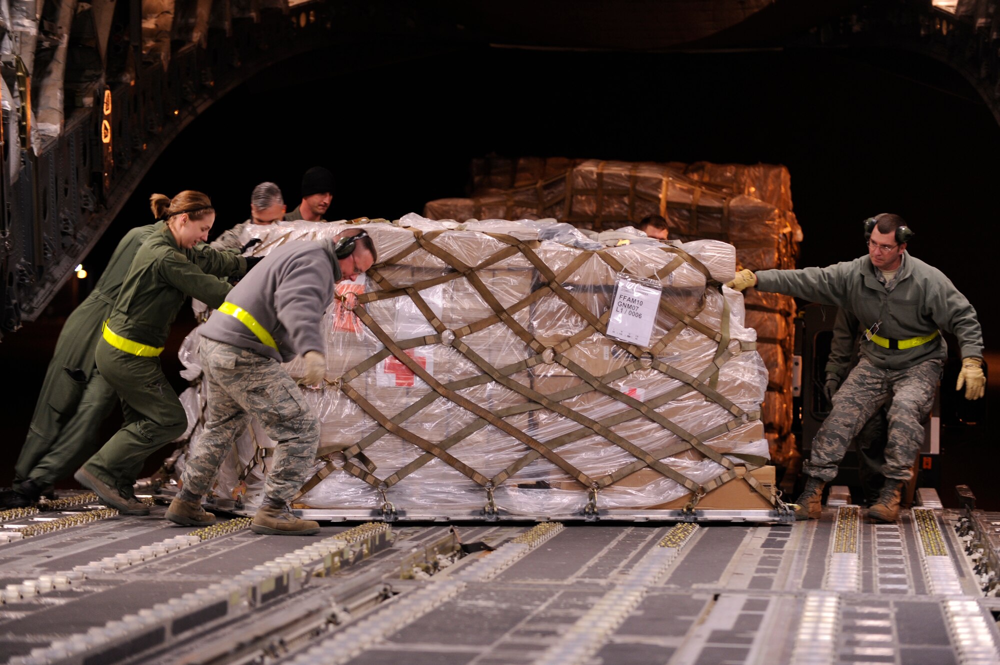Members of the 375th Logistics Readiness Squadron work to move one of 11 pallets of medical supplies into place on board a C-17 aircraft Jan. 17, 2010. The C-17 is taking two aeromedical crews and their supplies from the 375th Air Mobility Wing to MacDill Air Force Base, Fla., where they'll be staged for AE flights to and from Haiti.  The aircraft will then continue to Haiti to deliver medical supplies and an aeromedical evacuation team from U.S. Transportation Command. (U.S. Air Force photo/ Senior Airman Wesley Farnsworth)