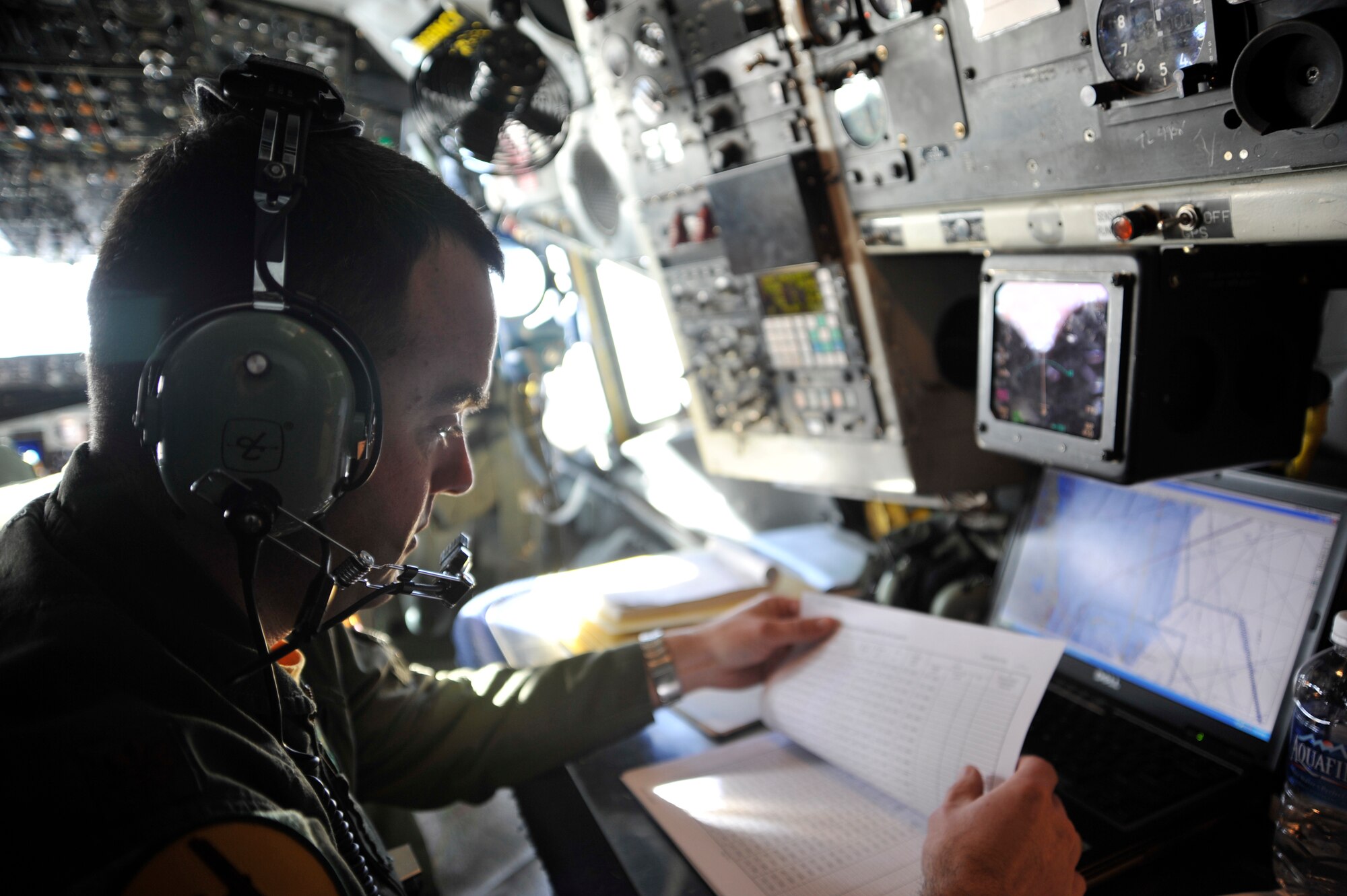Maj. Michael Vanone, Offutt AFB, NE, 45th Reconnaissance Squadron navigator, monitors navigational equipment in an OC-135B Observation Aircraft Jan 16 over Haiti. Army, Navy and Air Force personnel used the capabilities of the OC-135B to photograph Haiti, to get a better understanding of the devastation from the earthquake that hit the island Jan. 12. (U.S. Air Force photo by Airman 1st Class Perry Aston) (Released)