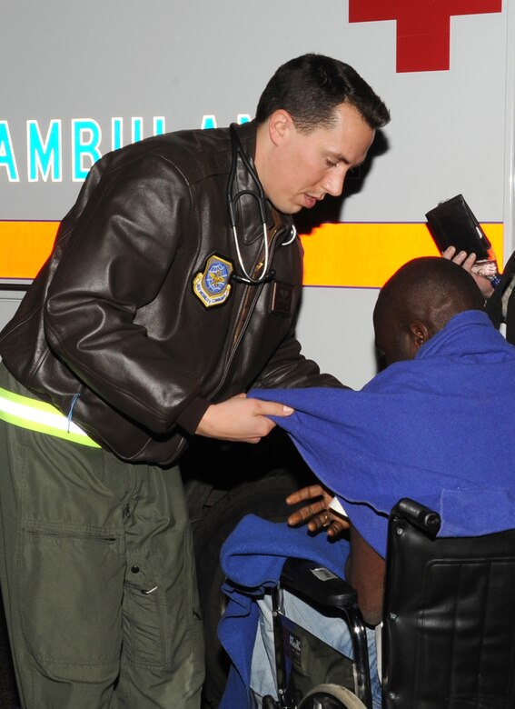 JOINT BASE MCGUIRE-DIX-LAKEHURST, N.J. – Captain Brent Mittelstadt, 87th Aeromedical Squadron flight surgeon, provides basic medical care to a Haitian evacuee shortly after a C-17 arrived with 44 survivors of Tuesday’s earthquake. The 87th Medical Group set up a clinic at the McGuire Fitness Center to provide care for the evacuees. (U.S. Air Force photo/Staff Sgt. Danielle Johnson)