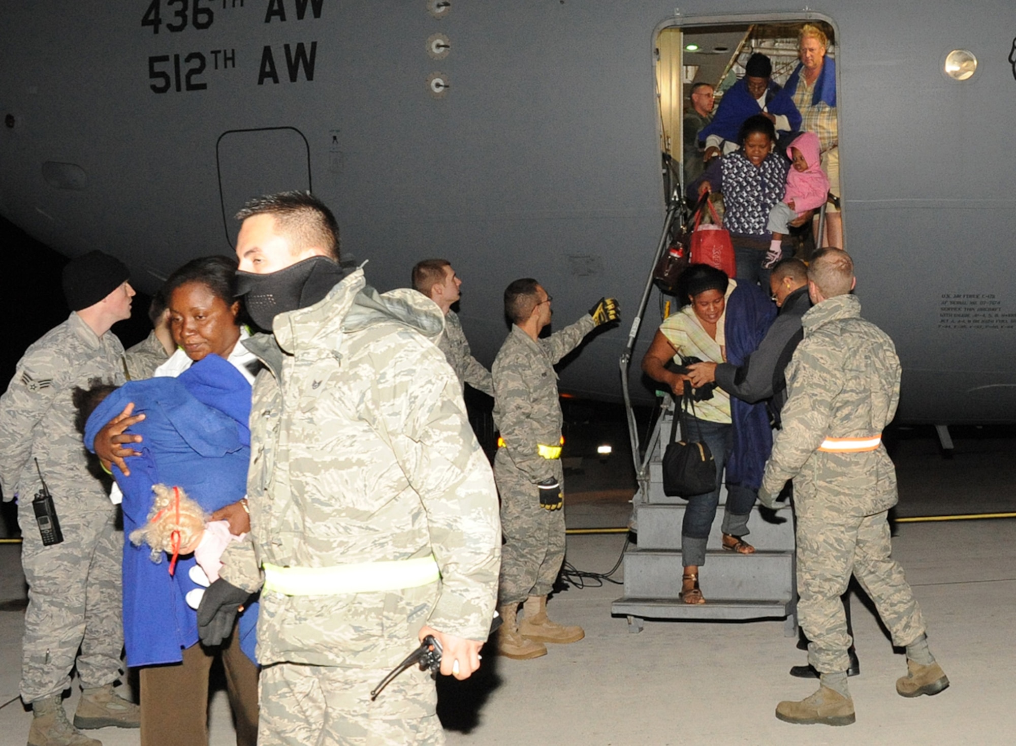 JOINT BASE MCGUIRE-DIX-LAKEHURST, N.J. –Airmen help evacuees from Haiti as they arrive here Saturday. More than 500 survivors of Tuesday’s earth quake have arrived at the joint base since the first evacuees arrived Friday morning. (U.S. Air Force photo/Staff Sgt. Danielle Johnson)