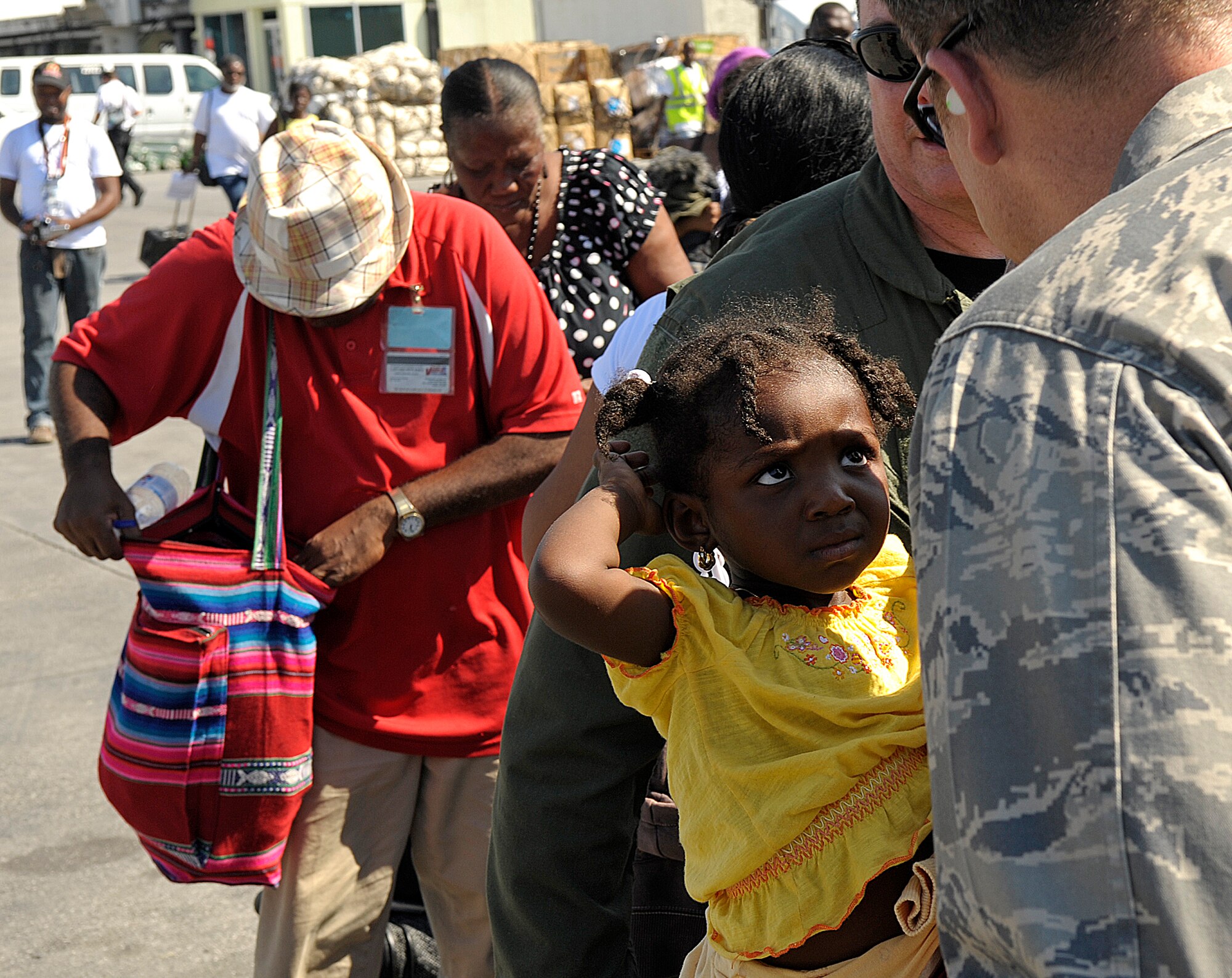 Lt. Col. Joseph Pocreva, 1st Special Operations Wing, Air Force Special Operations Command, speaks with a young Haitian girl at the Troussaint Louverture International Airport in Port-au-Prince, Haiti, Jan. 15. before she is evacuated to the United States. Port-au-Prince was devastated by an earthquake Jan. 12. (U.S. Air Force photo by Master Sgt. Russell E. Cooley IV)