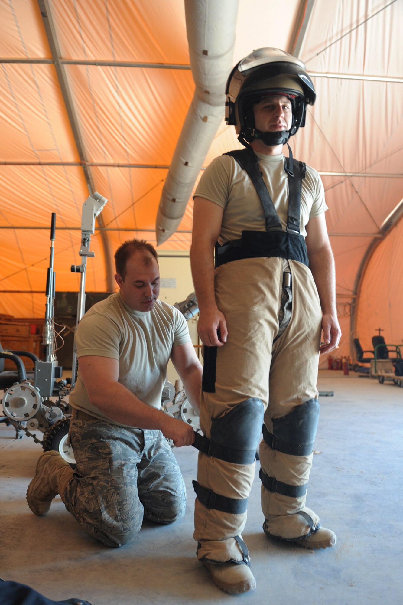 Staff. Sgt. Michael Duane, 379th Expeditionary Civil Engineering Squadron EOD craftsman helps Tech. Sgt. Neil Gertiser, also an EOD craftsman, don an EOD bomb suit at a non-disclosed Southwest Asia location, Jan. 14, 2010. The suit can withstand an explosion of five pounds of TNT at a distance of five feet. (U.S. Air Force photo/Tech. Sgt. Michelle Larche) [RELEASED]
