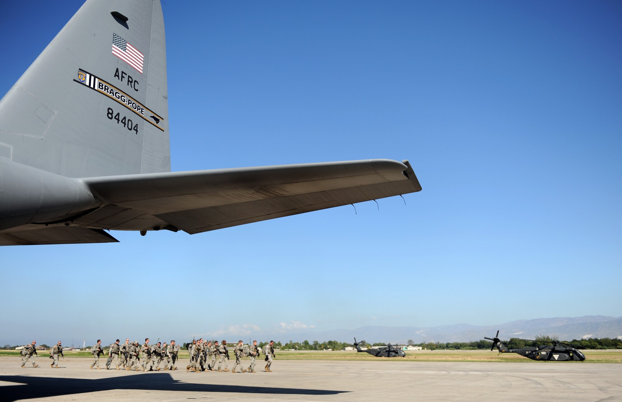100115-F-2034C-098Members of the 82nd Airborne Division walk past a C-130 Hercules Jan. 15, 2010 after arriving at Port-au-Prince, Haiti. The C-130, from the 2nd Airlift Squadron, Pope Air Force Base, Fayetteville, North Carolina, brought the Soldiers to Haiti as part of the relief efforts being conducted by the DoD. U.S. Southern Command is deploying assets to Haiti to conduct search and rescue operations, damage assessments, and transitions sustained Humanitarian Assistance/Disaster Relief operations in order to prevent human suffering and additional loss of life. (U.S. Air Force photo/Master Sgt. Shane A. Cuomo) 
