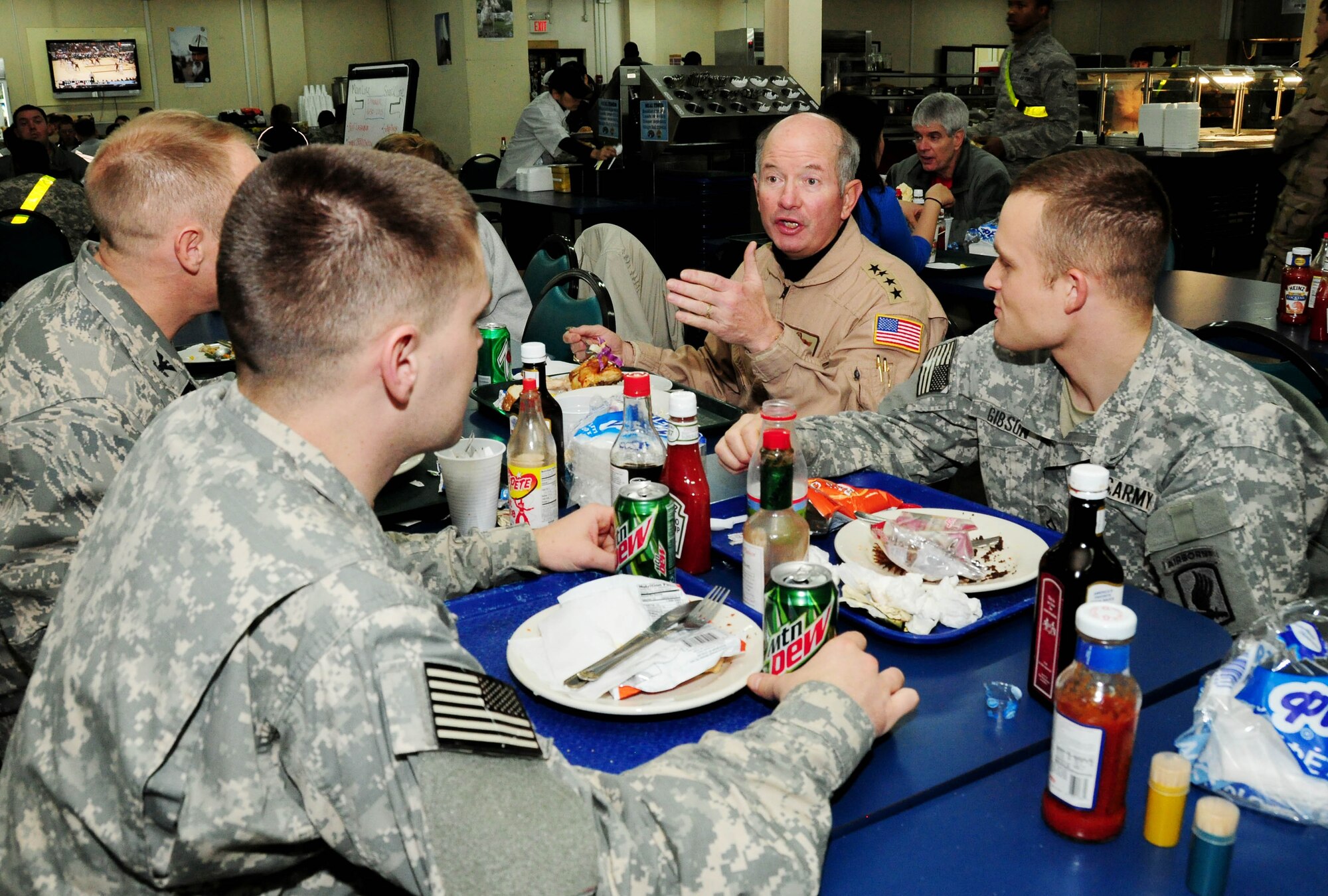 General Duncan J. McNabb, U.S. Transportation Command commander, and Col. Blaine Holt, 376th Air Expeditionary Wing commander, speak with Army Spc. Louis Schuster and Pfc. Jonathon Gibson, field artillery specialists from the 4-319 Airborne Field Artillery Regiment Bamberg, Germany Army Post, over dinner at the Transit Center at Manas' Ala' too Dining Facility here Jan. 16. The soldiers are transiting home from Forward Operating Base Airborne after a 12-month deployment. (U.S. Air Force photo by Senior Airman Nichelle Anderson)