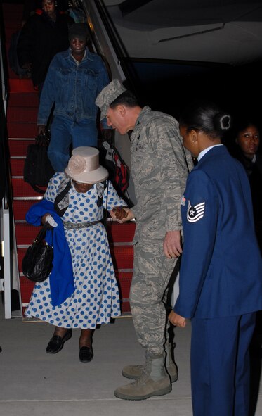 Colonel Steven M. Shepro, 316th Wing/Joint Base Andrews commander, assists a Haitian earthquake survivor while she disembarks from an 89th Airlift Wing C-32 Jan 17, 2010 on Joint Base Andrews. The survivors, all repatriated Americans, flew back to the U.S. with Secretary of State Hillary Clinton after her visit with Haitian President Rene Preval, pledging U.S. aid in the country's relief effort. (U.S. Navy photo by MC2 Clifford L. H. Davis)