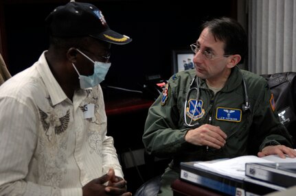 Colonel Lewis Hofmann, 779th Medical Group Pentagon Annex director, assists Joel Nicholas, a repatriated U.S. citizen, with his medical screening Jan. 17, 2010, at Joint Base Andrews. Mr. Nicholas and 21 other survivors of the 7.0-magnitude earthquake that hit Haiti Jan 12 returned to the U.S. with Secretary of State Hillary Clinton. (U.S. Air Force photo by Staff Sgt Melissa Stonecipher) 