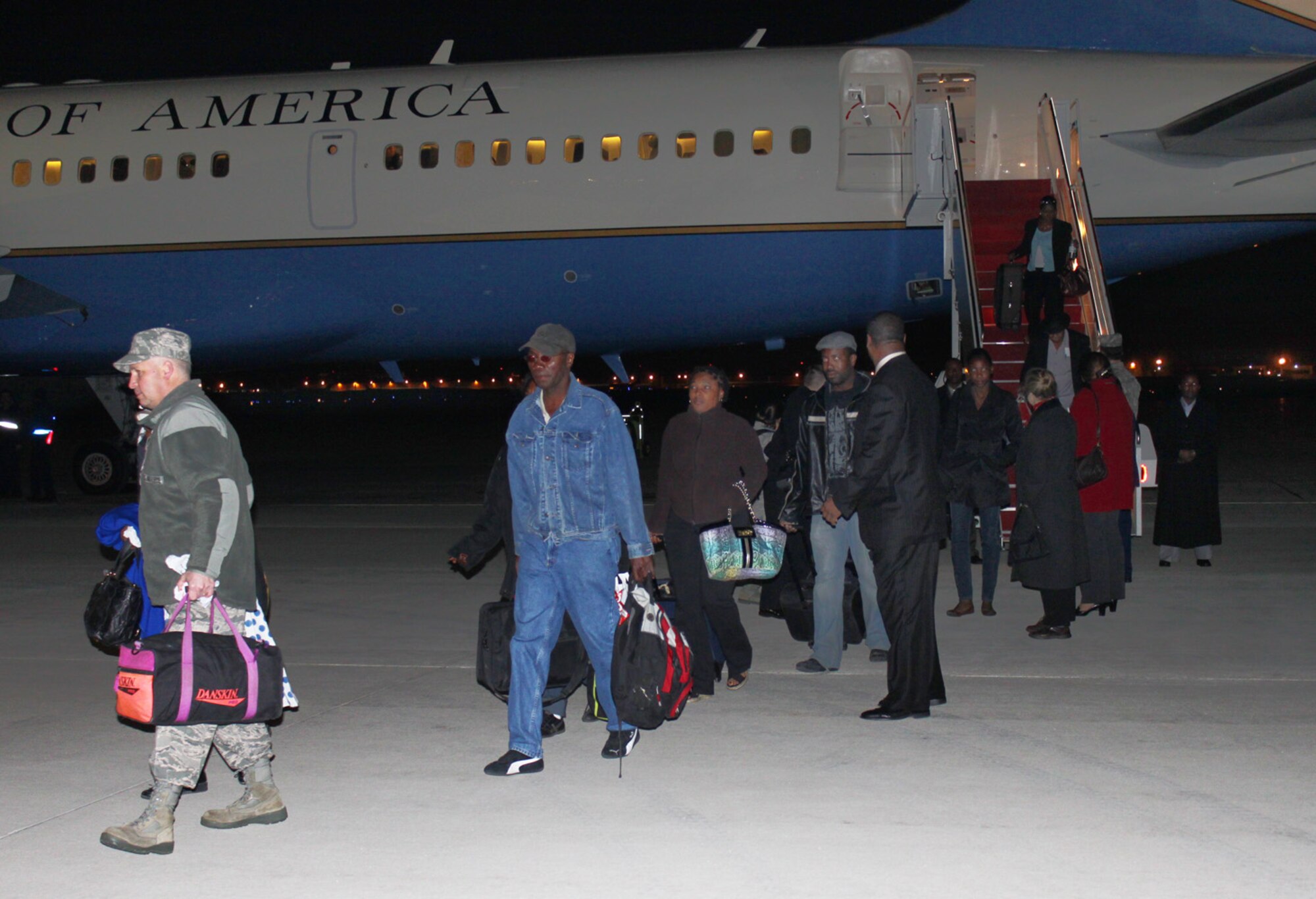 Colonel John Long, 316th Mission Support Group commander, left, helps repatriated U.S. citizens with their luggage as they disembark from an 89th Airlift Wing C-32 Jan. 17, 2010. Secretary of State Hillary Clinton traveled to Joint Base Andrews with 22 survivors of the 7.0-magnitude earthquake that hit Haiti Jan. 12. In Haiti, the secretary met with Haitian President Rene Preval and pledged U.S. aid in the country’s relief effort. The survivors were met upon arrival here by a medical team consisting of 79th Medical Wing personnel, Prince Georges County emergency technicians and Red Cross workers who ensured the passengers were in good health. (U.S. Air Force photo by Master Sgt. J.C. Woodring)