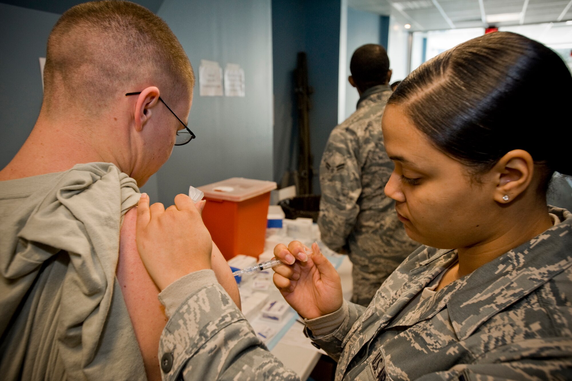 MISAWA AIR BASE, Japan -- Airman 1st Class Paula Sails, 35th Medical Support Squadron service accounts officer, administers an H1N1 flu shot to Airman 1st Class Joshua Buck, 35th Operations Support Squadron airfield management coordinator, Jan. 15 at the Richard Bong Training Facility. More than 800 active duty Airmen received the vaccination. (U.S. Air Force photo/Senior Airman Jamal D. Sutter)