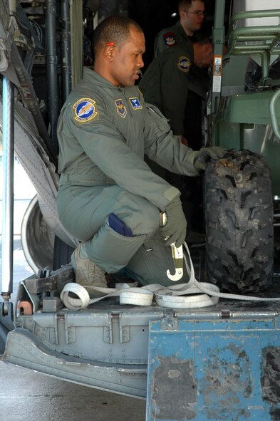 DYESS AIR FORCE BASE, Texas -- Staff Sgt. Henry Morgan, 317th Airlift Group, discusses the load aboard a C-130 Hercules with a fellow loadmaster Jan. 17 at an East Coast Air Force Base. The C-130 crew of six departed Dyess Air Force Base to support relief efforts following the 7.0-magnitude earthquake that devistated the Caribbean nation Jan. 14. The Air Force's airlift capability enables the United States to respond immediately to any disaster domestically or worldwide. We are the only country with an aircraft fleet capable of providing this type of response.