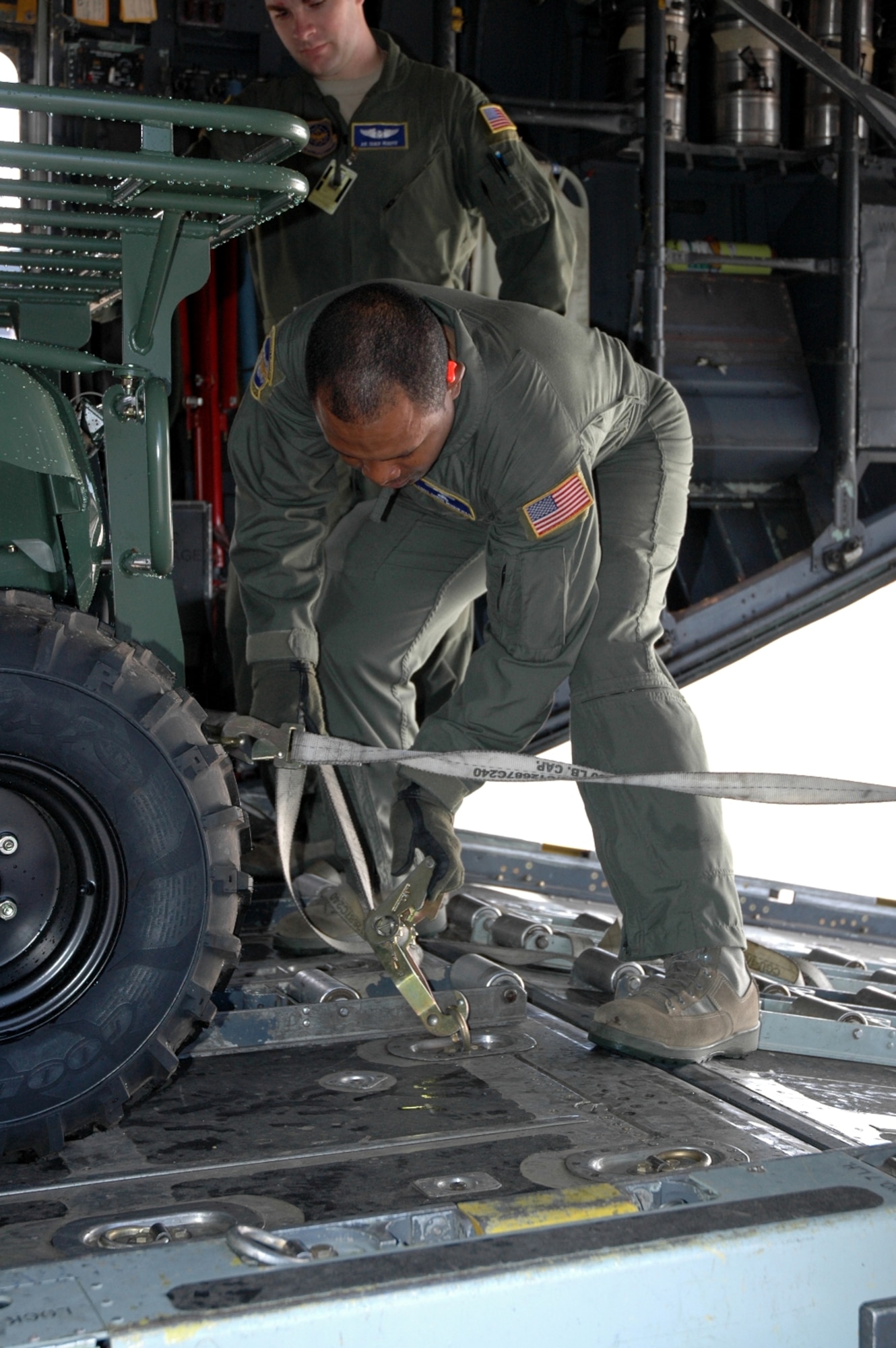 DYESS AIR FORCE BASE, Texas -- Tech. Sgt. Chris Minnifield, 317th Airlift Group, ratches down a “Gator,” six wheeled utility vehicle,  bound for Haiti Jan. 17 at an East Coast Air Force Base. The C-130 crew of six departed Dyess Air Force Base to support relief efforts following the 7.0-magnitude earthquake that devistated the Caribbean nation Jan. 14. The Air Force's airlift capability enables the United States to respond immediately to any disaster domestically or worldwide. We are the only country with an aircraft fleet capable of providing this type of response.