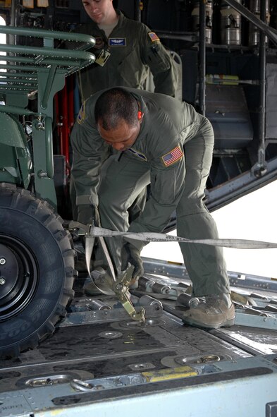 DYESS AIR FORCE BASE, Texas -- Tech. Sgt. Chris Minnifield, 317th Airlift Group, ratches down a “Gator,” six wheeled utility vehicle,  bound for Haiti Jan. 17 at an East Coast Air Force Base. The C-130 crew of six departed Dyess Air Force Base to support relief efforts following the 7.0-magnitude earthquake that devistated the Caribbean nation Jan. 14. The Air Force's airlift capability enables the United States to respond immediately to any disaster domestically or worldwide. We are the only country with an aircraft fleet capable of providing this type of response.
