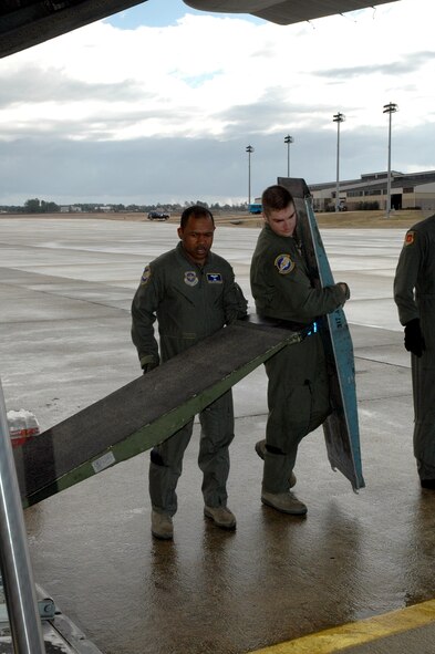 DYESS AIR FORCE BASE, Texas -- Tech. Sgt. Chris Minnifield and Airman 1st Class Derek Murphy, 317th Airlift Group, place ramps on the back of a C-130 Hercules Jan. 17 at an East Coast Air Force Base to load a “Gator,” six wheeled utility vehicle, bound for Haiti. The C-130 crew of six departed Dyess Air Force Base to support relief efforts following the 7.0-magnitude earthquake that devistated the Caribbean nation Jan. 14. The Air Force's airlift capability enables the United States to respond immediately to any disaster domestically or worldwide. We are the only country with an aircraft fleet capable of providing this type of response