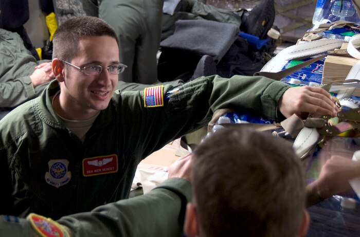 Senior Airman Nick Hebert talks with fellow crew members before embarking a humanitarian mission for Haiti aboard a McChord C-17 on the Charleston AFB flightline Jan. 18. The mission was the first of many missions to be flown out of Charleston AFB laden with food and water to aid victims of the recent earthquake in Haiti. Airman Hebert is a loadmaster with the 10th Airlift Squadron, McChord AFB, Wash. (U.S. Air Force photo/Staff Sgt. Daniel Bowles)