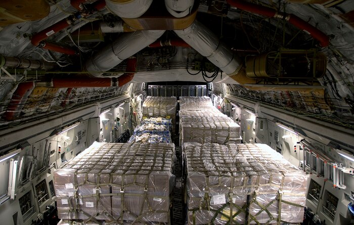 Nine pallets of bottled water and seven pallets of Meals-Ready-to-Eat sit on a McChord AFB C-17 after being loaded at Charleston AFB Jan. 18. Members of the 437th Aerial Port Squadron and 10th Airlift Squadron loadmasters worked together to load the 16 pallets, which weighed approximately 116,000 pounds and included more than 40,000 bottles of water and 30,000 meals. The supplies were flown out of Charleston AFB at approximately 6:30 a.m. on the first mission to leave the base since it assumed the role of a distribution hub for food and water to Haiti. (U.S. Air Force photo/Staff Sgt. Daniel Bowles)