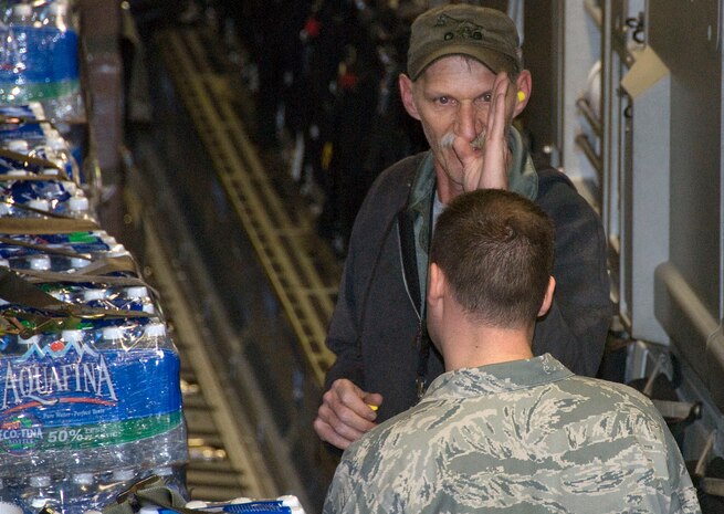 Lawrence Curtis talks with Tech. Sgt. Sean Stottlemyer about the position of wooden dunnage secured to the tops of pallets of water onboard a McChord C-17 on the Charleston AFB flightline Jan. 18. The dunnage must be positioned laterally across the tops of the pallets to ensure they can not slide out from under their cargo straps during flight. Mr. Curtis is a work leader and Sergeant Stottlemyer is a night shift supervisor, both are with the 437th Aerial Port Squadron ramp services section. (U.S. Air Force photo/Staff Sgt. Daniel Bowles)