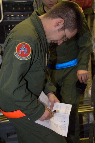Senior Airman Nick Hebert documents data on the load plan for a shipment of food and water aboard a McChord C-17 on the Charleston AFB flightline Jan. 18. Sixteen pallets of food and water were loaded during the first of many missions to be flown out of Charleston AFB with supplies to aid victims of the recent earthquake in Haiti. Airman Hebert is a loadmaster with the 10th Airlift Squadron, McChord AFB, Wash. (U.S. Air Force photo/Staff Sgt. Daniel Bowles)
