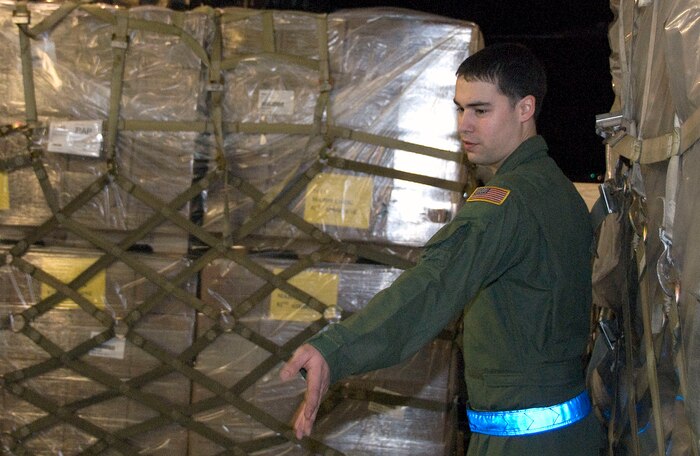 Senior Airman Anthony Jimenez gives directions for aligning a pallet of Meals-Ready-to-Eat aboard a McChord C-17 on the Charleston AFB flightline Jan. 18. The pallet contained more than 4,500 meals and was shipped to Haiti as part of the humanitarian relief effort to aid victims of the recent earthquake. Airman Jimenez is a loadmaster with the 10th Airlift Squadron, McChord AFB, Wash. (U.S. Air Force photo/Staff Sgt. Daniel Bowles)