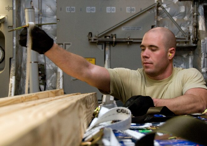 Airman 1st Class Jason Cox secures dunnage to the top of a pallet of water aboard a McChord AFB C-17 on the Charleston AFB flightline Jan. 18. The dunnage is used to support the pallet of water after it is off-loaded from the aircraft. Airman Cox is an air transportation journeyman with the 437th Aerial Port Squadron. (U.S. Air Force photo/Staff Sgt. Daniel Bowles)