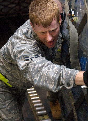 Airman 1st Class James Harrison strains to push a pallet of bottled water onto a McChord AFB C-17 on the Charleston AFB flightline Jan. 18. The pallet of water weighed several thousand pounds and was one of nine loaded for shipment to victims of the recent earthquake in Haiti. Airman Harrison is an air transportation journeyman with the 437th Aerial Port Squadron. (U.S. Air Force photo/Staff Sgt. Daniel Bowles)