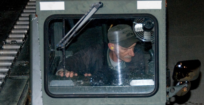 Lawrence Curtis checks his side-view mirror as he reverses a Tunner 60K Loader from the rear of a McChord C-17 on the Charleston AFB flightline Jan. 18. The industrial loading vehicle is used to transport several pallets at a time to the aircraft at one time, allowing loading specialists to move from one pallet to the next with little delay. Mr. Curtis is a work leader with the 437th Aerial Port Squadron ramp services section. (U.S. Air Force photo/Staff Sgt. Daniel Bowles)