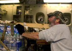 William Leeson pushes a pallet of bottled water onto a McChord AFB C-17 on the Charleston AFB flightline Jan. 18. The loadout included 16 pallets of relief supplies, totaling 116,000 pounds, and was loaded by 437th Aerial Port Squadron members and 10th Airlift Squadron loadmasters in under 38 minutes. (U.S. Air Force photo/Staff Sgt. Daniel Bowles)
