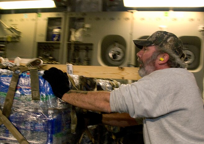 William Leeson pushes a pallet of bottled water onto a McChord AFB C-17 on the Charleston AFB flightline Jan. 18. The loadout included 16 pallets of relief supplies, totaling 116,000 pounds, and was loaded by 437th Aerial Port Squadron members and 10th Airlift Squadron loadmasters in under 38 minutes. (U.S. Air Force photo/Staff Sgt. Daniel Bowles)