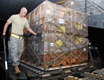 Airman 1st Class Jason Cox watches over a pallet filled with food as it is transferred onto a McChord AFB C-17 on the Charleston AFB flightline Jan. 18. The pallet of food weighed approximately 9,000 pounds and was loaded for shipment to victims of the recent earthquake in Haiti. Airman Cox is an air transportation journeyman with the 437th Aerial Port Squadron. (U.S. Air Force photo/Staff Sgt. Daniel Bowles)