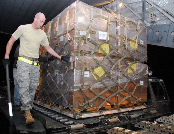 Airman 1st Class Jason Cox watches over a pallet filled with food as it is transferred onto a McChord AFB C-17 on the Charleston AFB flightline Jan. 18. The pallet of food weighed approximately 9,000 pounds and was loaded for shipment to victims of the recent earthquake in Haiti. Airman Cox is an air transportation journeyman with the 437th Aerial Port Squadron. (U.S. Air Force photo/Staff Sgt. Daniel Bowles)