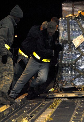 Air transportation specialists with the 437th Aerial Port Squadron work together to properly align a pallet of water to be loaded on a McChord AFB C-17 on the Charleston AFB flightline Jan. 18. The pallet of water was loaded as part of the first humanitarian mission to leave Charleston AFB laden with food and water to aid victims of the recent earthquake in Haiti. (U.S. Air Force photo/Staff Sgt. Daniel Bowles)