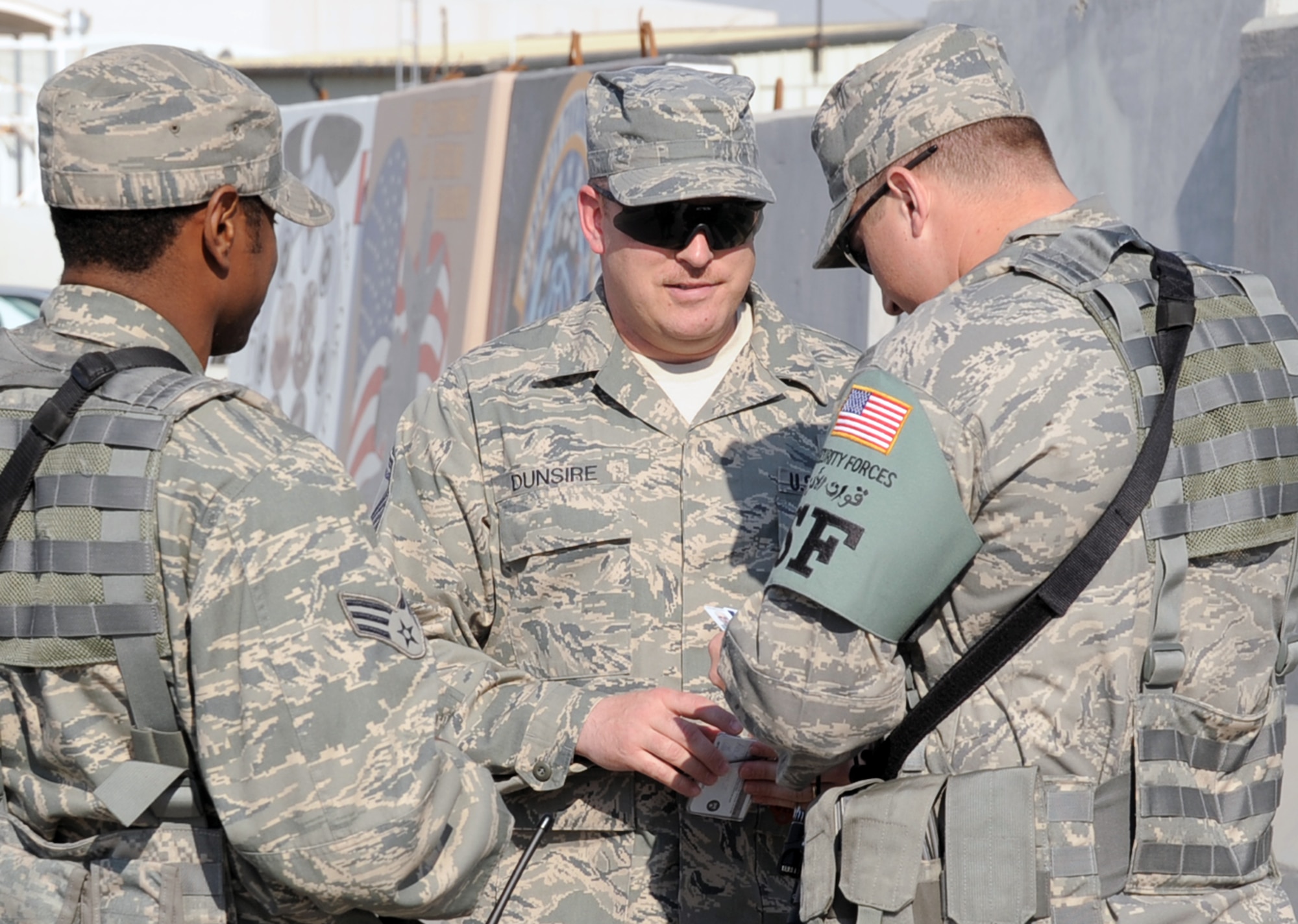 Senior Airmen Jeffery Fitzgerald and George Clark, both security forces journeymen with the 380th Expeditionary Security Forces Squadron, check the identification of Senior Master Sgt. Alexander Dunsire III, 380th ESFS operations superintendent, during a checkpoint check by Sergeant Dunsire during operations at a non-disclosed base in Southwest Asia on Jan. 16, 2010. The 380th ESFS, as part of the 380th Air Expeditionary Wing, supports Operations Iraqi Freedom and Enduring Freedom and the Combined Joint Task Force-Horn of Africa. (U.S. Air Force Photo/Tech. Sgt. Scott T. Sturkol/Released)