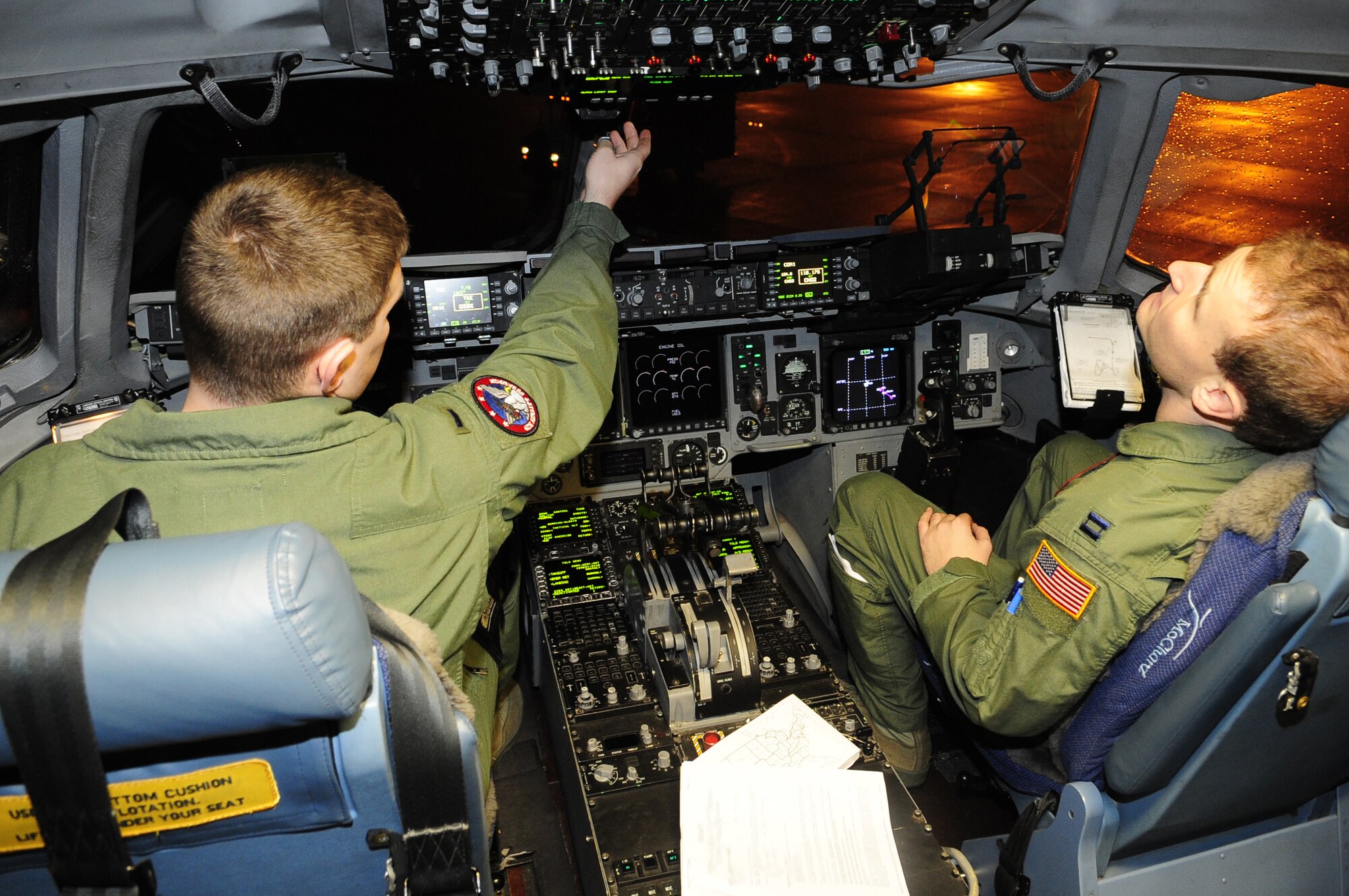 1st Lt. Nathan Moseley, co-pilot, and Capt. Anthony Cappel, mission commander, left, both 4th Airlift Squadron, conduct pre-flight checks on the flight deck before take-off early Sunday morning for Langley Air Force Base, Va. Two additional C-17s were dispatched Sunday to Pope AFB, N.C. and Charleston AFB, S.C., respectively, to pick up critical supplies and deliver them to Haiti; a fourth C-17 departed Jan. 18 for Pope. (Courtesy photo)