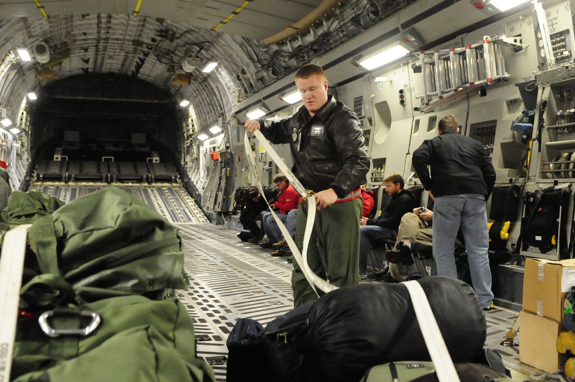 Staff Sgt. James Harp, 4th Airlift Squadron loadmaster, secures gear prior to takeoff Sunday morning for Langley Air Force Base, Va. Two additional C-17s were dispatched Sunday to Pope AFB, N.C. and Charleston AFB, S.C., respectively, to pick up critical supplies and deliver them to Haiti; a fourth C-17 departed Jan. 18 for Pope. (Courtesy photo)