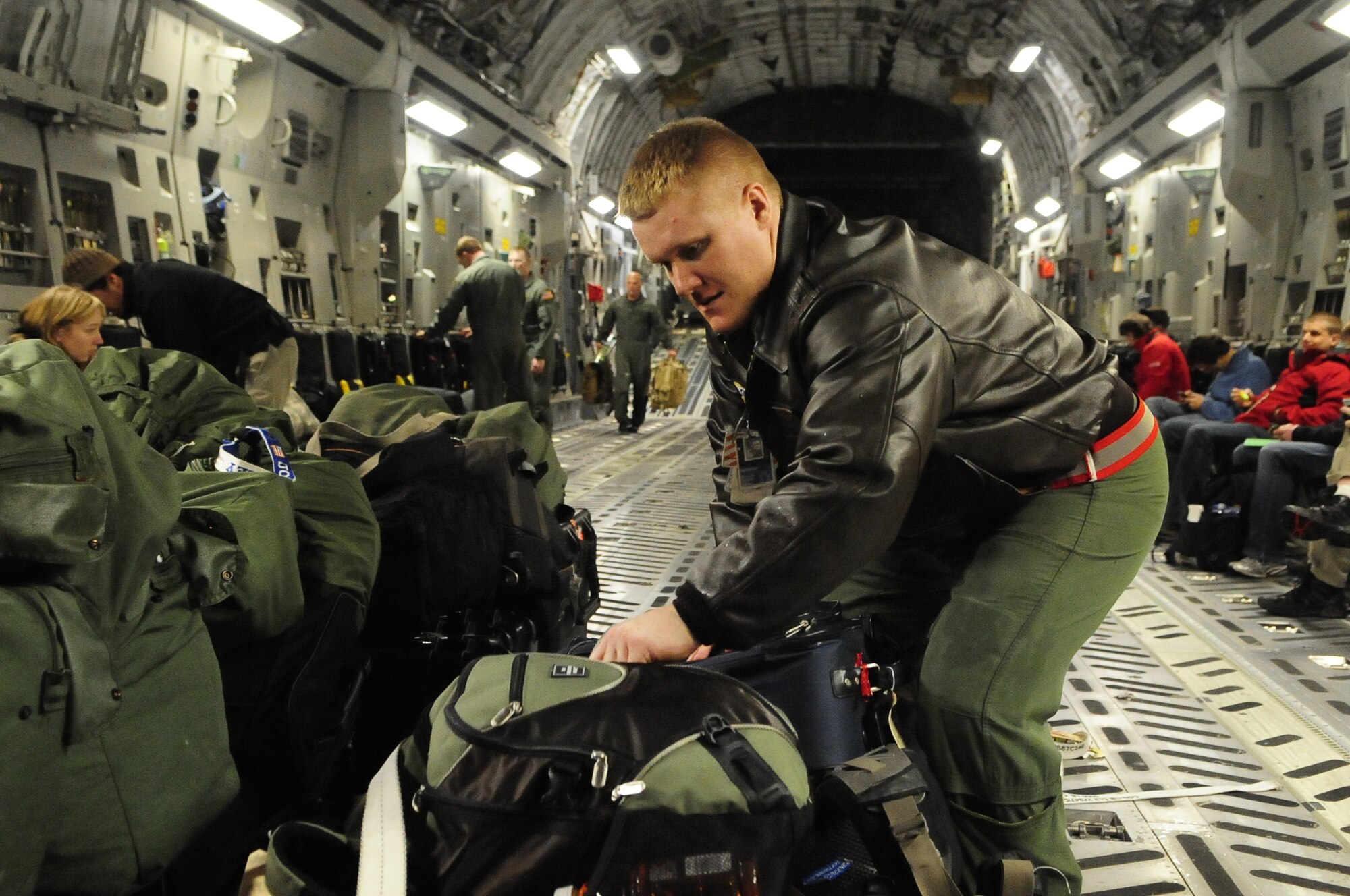 Staff Sgt. James Harp, 4th Airlift Squadron loadmaster, secures gear prior to takeoff Sunday morning for Langley Air Force Base, Va. Two additional C-17s were dispatched Sunday to Pope AFB, N.C. and Charleston AFB, S.C., respectively, to pick up critical supplies and deliver them to Haiti; a fourth C-17 departed Jan. 18 for Pope. (Courtesy photo)