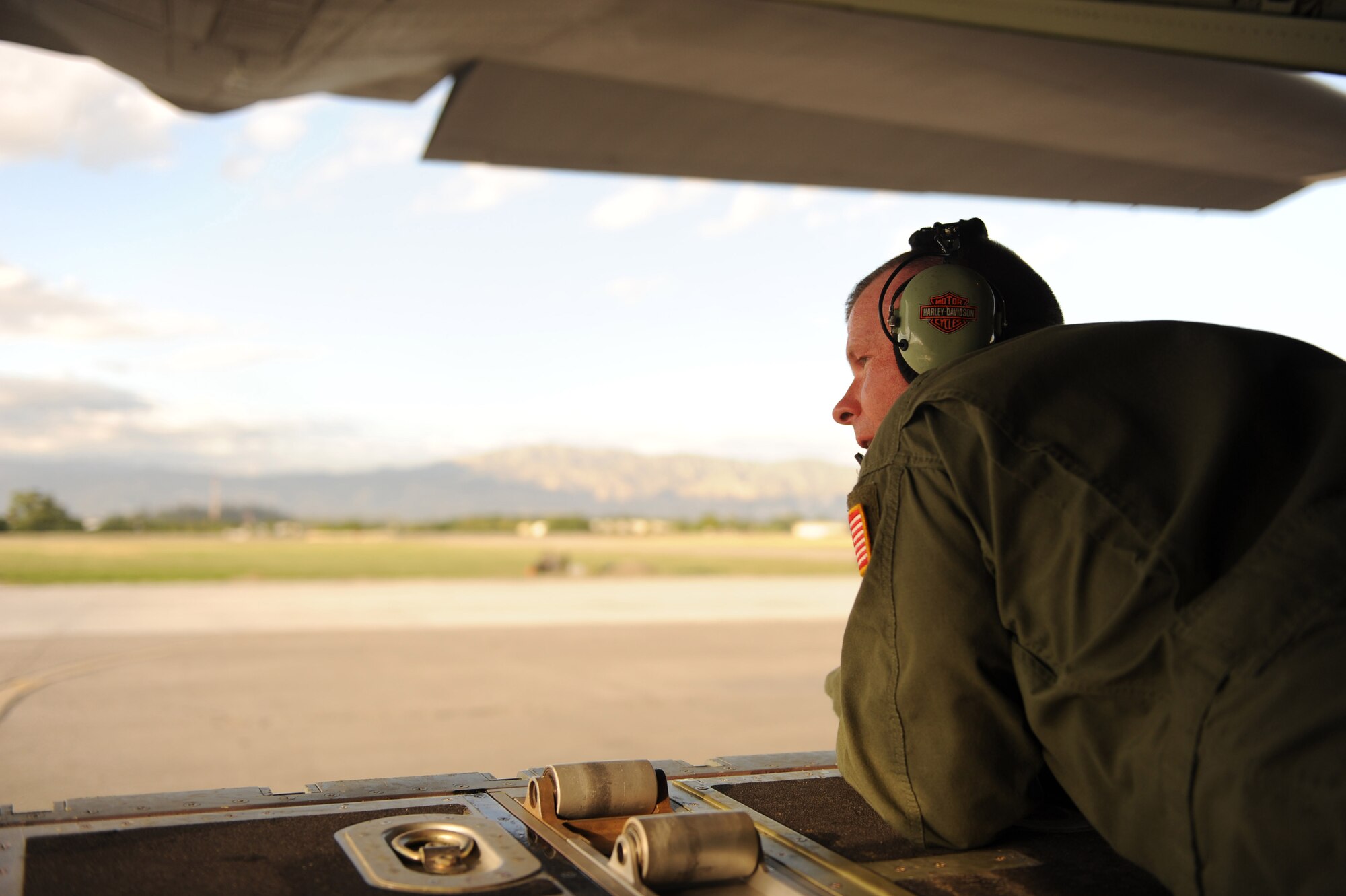 U.S. Air Force Tech. Sgt. Charles Moore, a loadmaster from the 41st Airlift Squadron, Little Rock Air Force Base, Ark., talks to the pilot while keeping a watch on the flightline at Port-au-Prince International Airport, Haiti, Jan.14, 2010.  Sergeant Moore is providing critical directional information to the pilot as the aircraft reverses direction while preparing to taxi.  Little Rock AFB is a component of Air Mobility Command. Since relief operations began Jan. 13, 2010, AMC aircraft have deliver more than 323 tons of emergency tons of cargo to Haiti. (USAF Photo by Staff Sgt. Chad Chisholm) (RELEASED)
