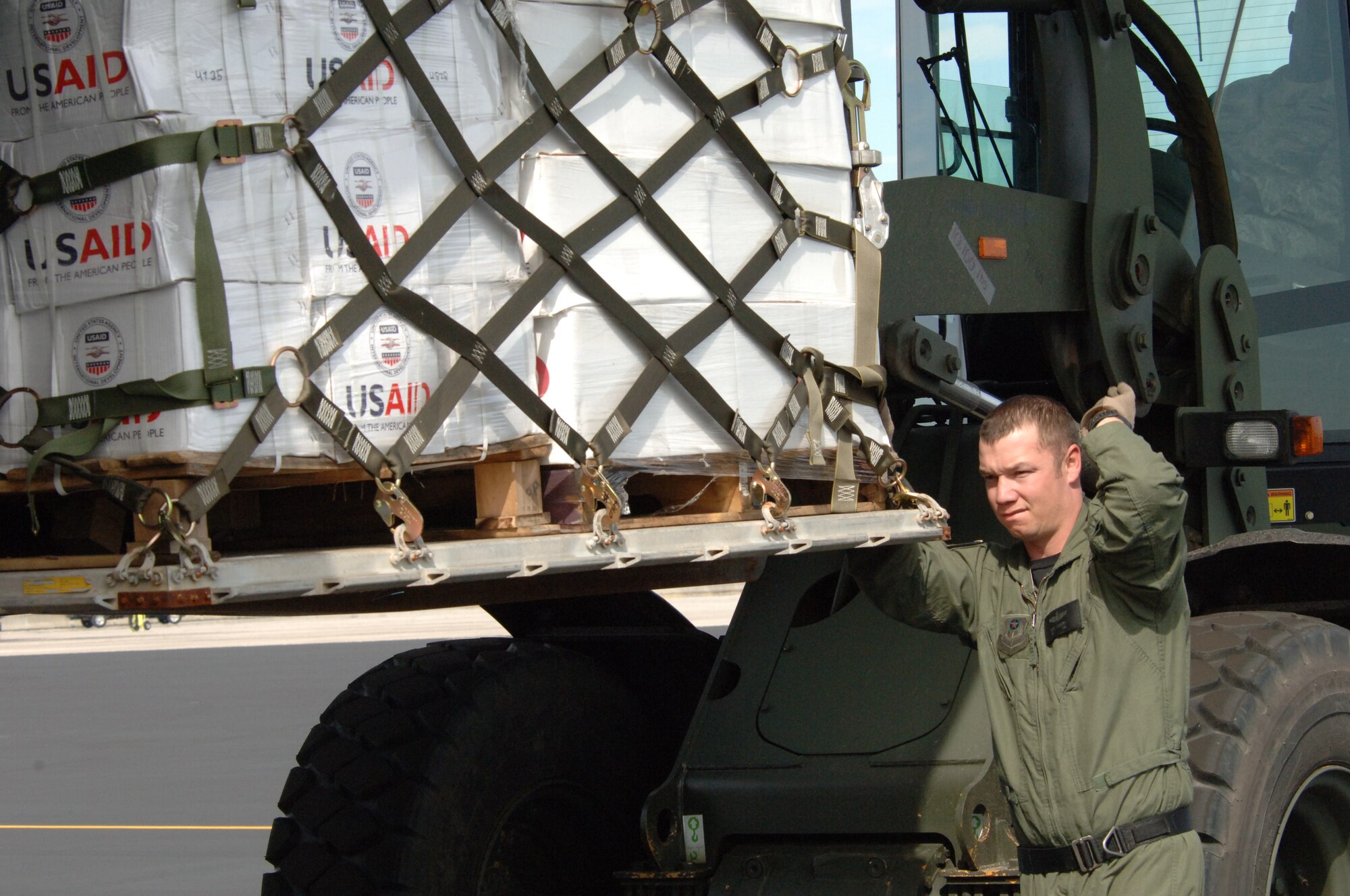 Staff. Seargent Dave Sanders, 15th Special Operations Squadron, from Hurlburt  guides a palet of USAID packages onto a C-130 at Homestead Air Reserve Base, Fla., Jan 18. Supplies are constantly on route to Haiti in support of Operation Unified Response. (U.S. Air Force photo by Tech. Sergeant  Andy Bellamy)   