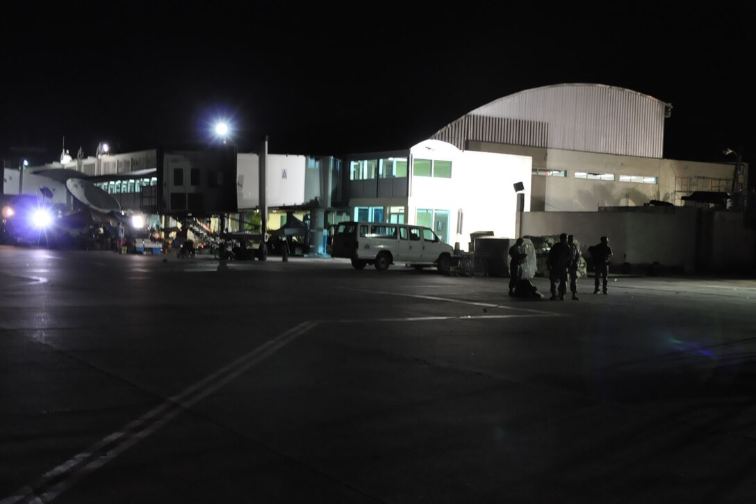 PORT-AU-PRINCE INTERNATIONAL AIRPORT, Haiti -- U.S. Military medical personnel stand on the tarmac outside of hangar here after arriving via a C-130H Hercules tactical cargo transport aircraft assigned to Air Force 
Reserve Command's 910th Airlift Wing, January 18. The medical personnel, consisting of U.S. Army and Air Force Servicemembers were flown, by the 910th's C-130, to Haiti from Soto Cano Air Base, Honduras. The 910th, based at Youngstown Air Reserve Station, Ohio, has three aircraft and crews supporting the relief effort in the aftermath of a major earthquake that devastated Port-au-Prince and the surrounding areas. Currently more than 30 personnel from the 910th are flying relief effort missions with a myriad of Citizen Airmen working at YARS to provide home station support to the crews. The 910th Airlift Wing stands ready to provide airlift capabilities to the massive humanitarian effort as long as needed by mission requirements. 
