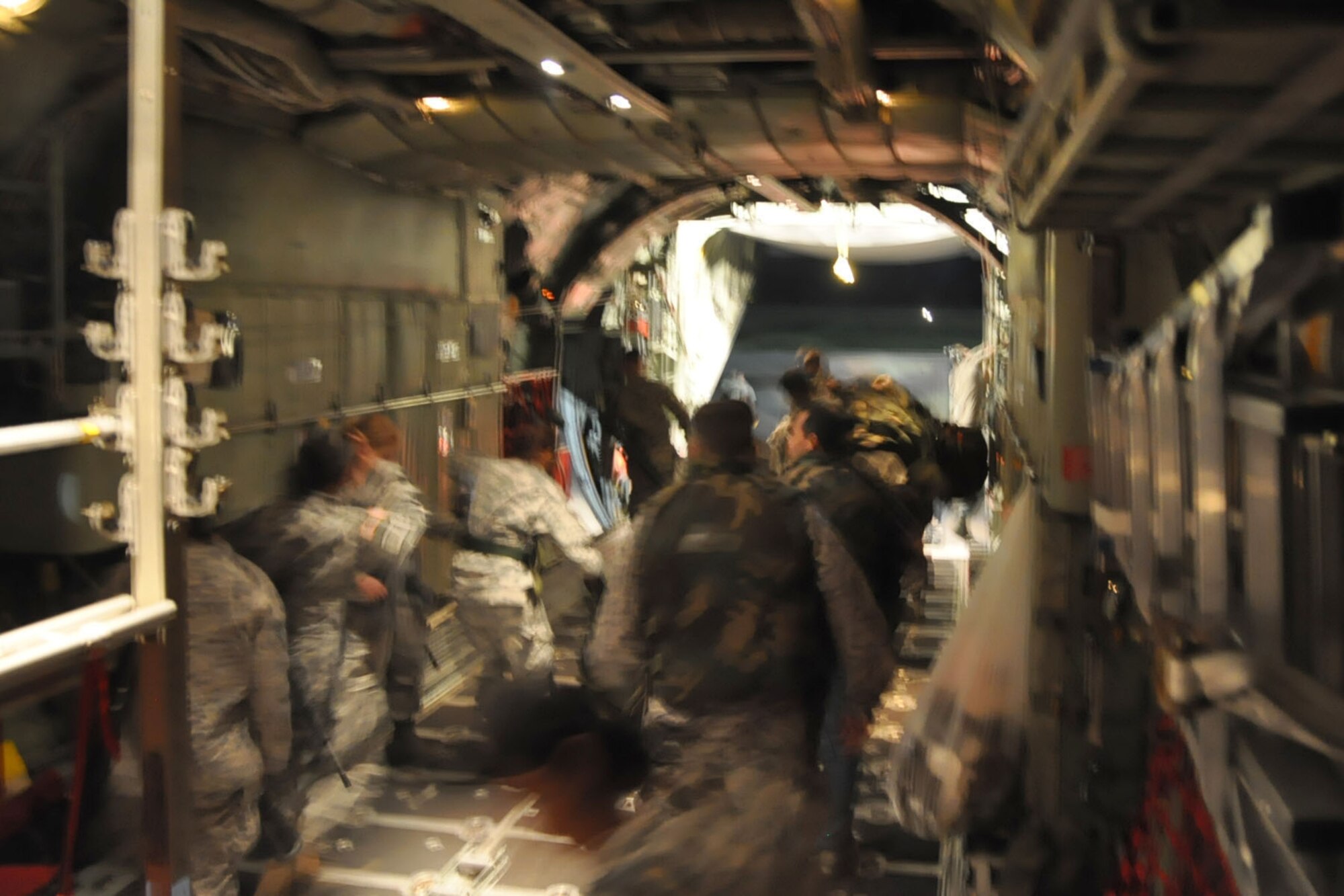 PORT-AU-PRINCE INTERNATIONAL AIRPORT, Haiti -- A group of 19 U.S. Military medical personnel walk through the cargo deck of a C-130H Hercules tactical cargo transport aircraft assigned to Air Force Reserve Command's 910th Airlift Wing on the tarmac here, January 18. The medical personnel, consisting of U.S. Army and Air Force Servicemembers were flown, by the 910th's C-130 to Haiti from Soto Cano Air Base, Honduras. The 910th, based at Youngstown Air Reserve Station, Ohio, has three aircraft and crews supporting the relief effort in the aftermath of a major earthquake that devastated Port-au-Prince and the surrounding areas. Currently more than 30 personnel from the 910th are flying relief effort missions with a myriad of Citizen Airmen working at YARS to provide home station support to the crews. The 910th Airlift Wing stands ready to provide airlift capabilities to the massive humanitarian effort as long as needed by mission requirements.