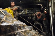 SOTO CANO AIR BASE, Honduras -- Air Force Reserve Master Sgt. Steve Gonzales, a crew chief assigned to the 910th Aircraft Maintenance Squadron and Staff Sgt. Michael Culp, a loadmaster assigned to the 773rd Airlift Squadron, work together to tighten a cargo strap securing a pallet to the rear cargo deck of a C-130H Hercules tactical cargo transport aircraft, assigned to the 910th Airlift Wing, on the cargo ramp here, January 17. Sergeants Gonzales and Culp are part of a 12-person crew from the 910th, based at Youngstown Air Reserve Station, Ohio, scheduled to deliver the pallet, a HUMVEE military vehicle, a trailer and supplies along with a group of 19 U.S. Military medical personnel to Port-au-Prince International Airport, Haiti as part of the relief effort to aid the people of the stricken island nation in the aftermath of the massive earthquake that devastated Port-au-Prince and surrounding areas last week. The 910th currently has three aircraft, crews of more than 30 personnel flying relief effort missions and a myriad of Citizen Airmen working at YARS to provide home station support to the crews. The 910th Airlift Wing stands ready to provide airlift capabilities to the massive humanitarian effort as long as needed by mission requirements.